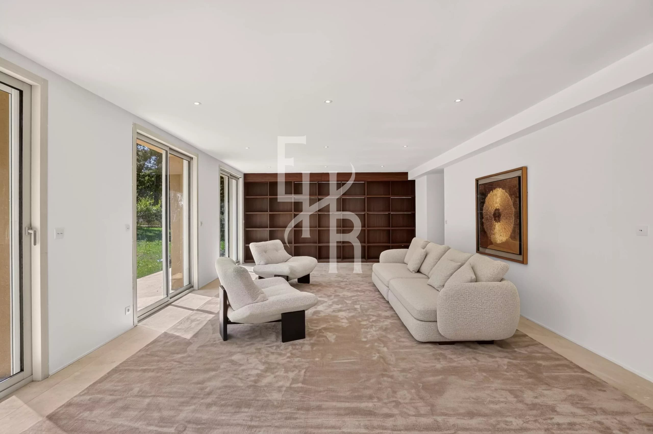 Salon moderne de la villa à Mougins Intérieur d'une villa moderne à Mougins avec un salon lumineux et des fenêtres donnant sur le jardin.