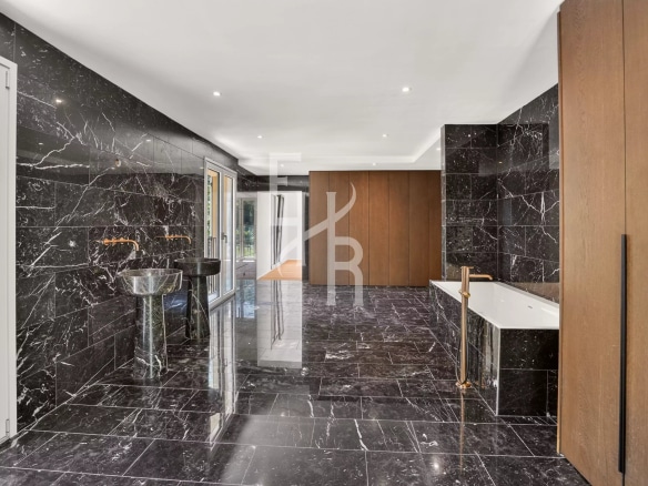 Intérieur moderne d'une villa avec murs en marbre noir et éléments en bois à Mougins.