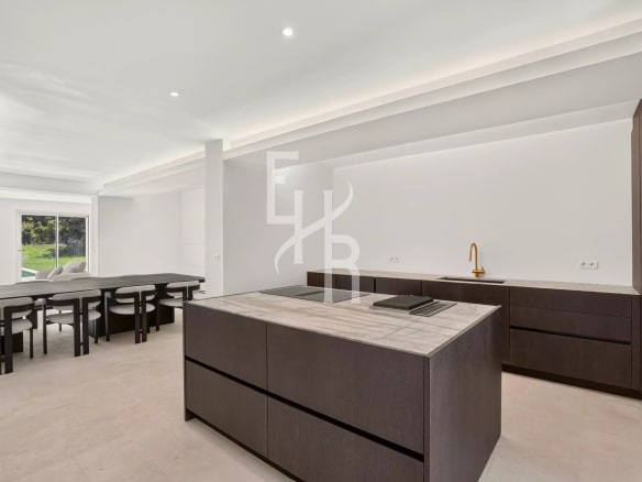 Cuisine moderne avec îlot central et table à manger dans un espace lumineux.