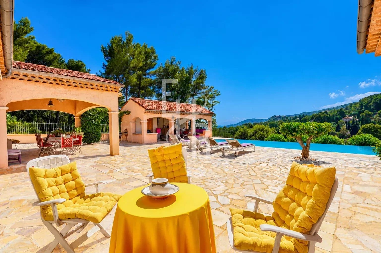 Sunny terrace with yellow chairs and panoramic views of nature in Cabris.