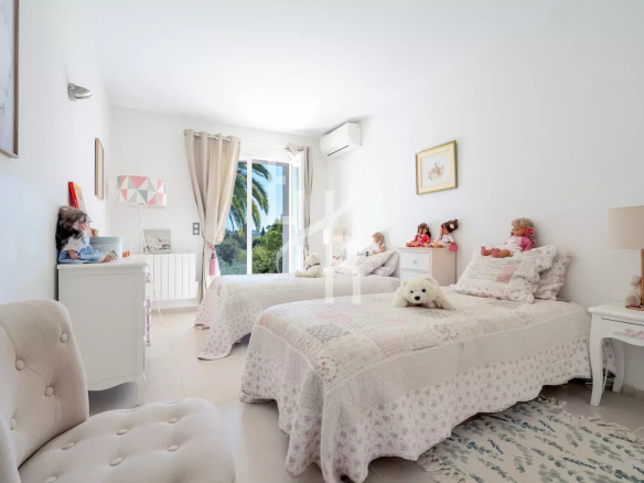 Children's bedroom with two single beds and soft decorations in a villa in Mougins.