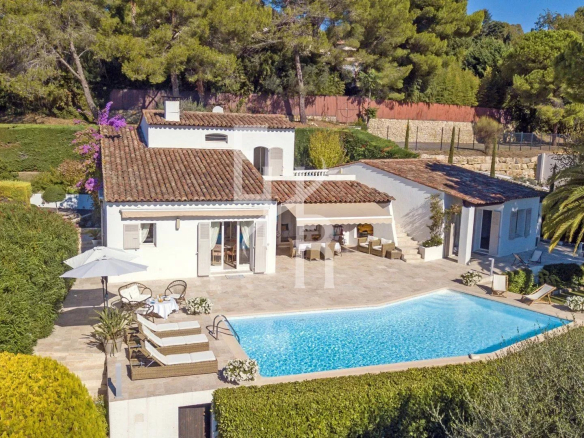 Villa with swimming pool and panoramic views of the village of Mougins, surrounded by greenery.