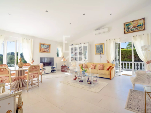 Bright interior of a villa in Mougins with living room, television and access to the outside.