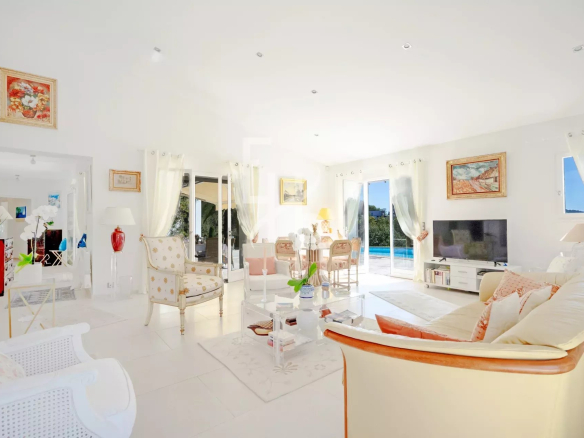 Interior of a bright villa in Mougins with living room, open-plan kitchen and patio.