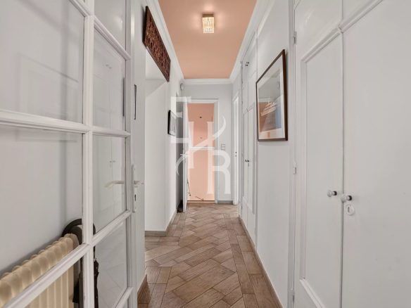 Couloir d'une villa familiale à Opio, avec murs blancs et carrelage au sol.
