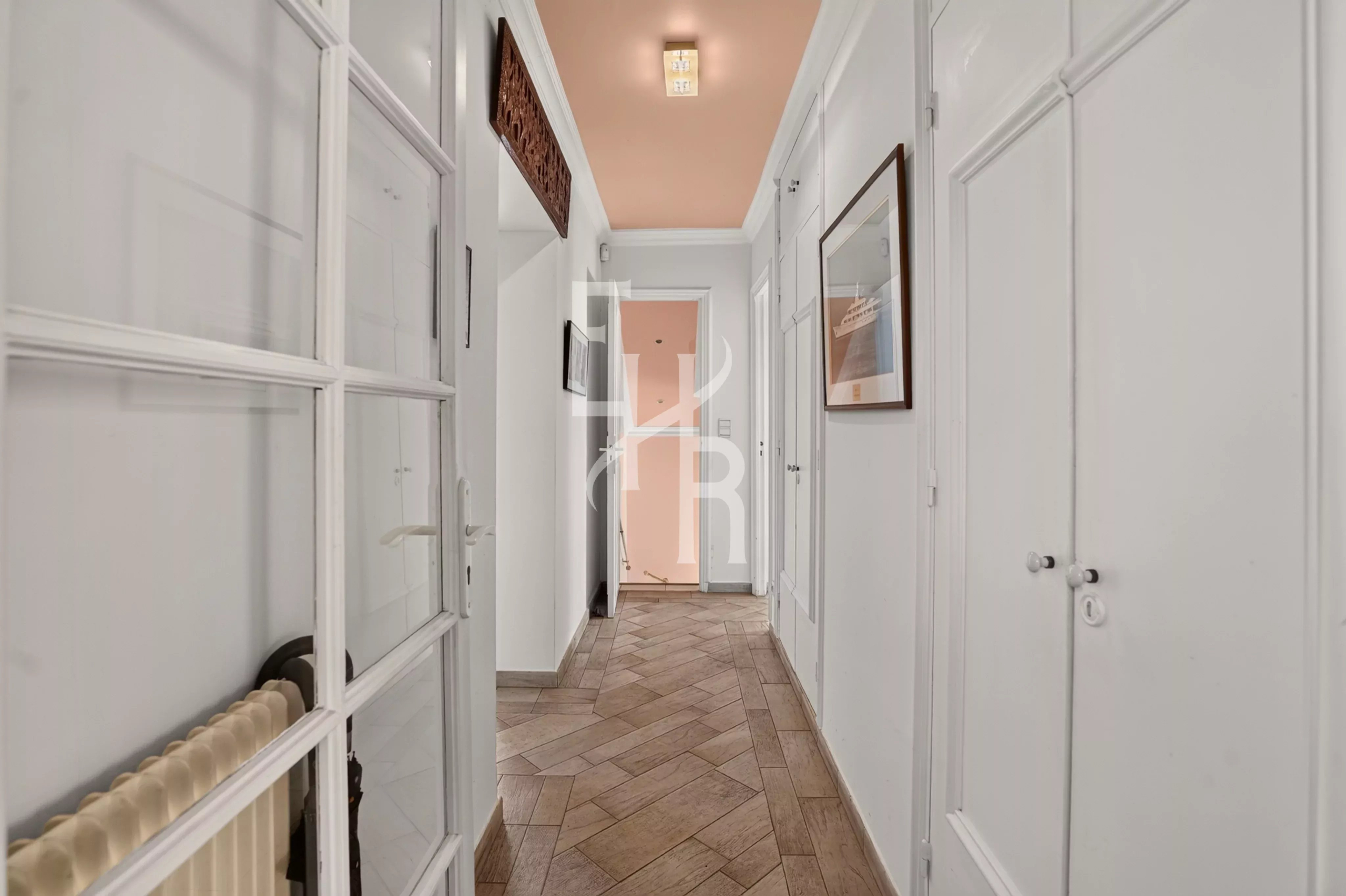 Intérieur d’une villa à Opio Couloir d'une villa familiale à Opio, avec murs blancs et carrelage au sol.