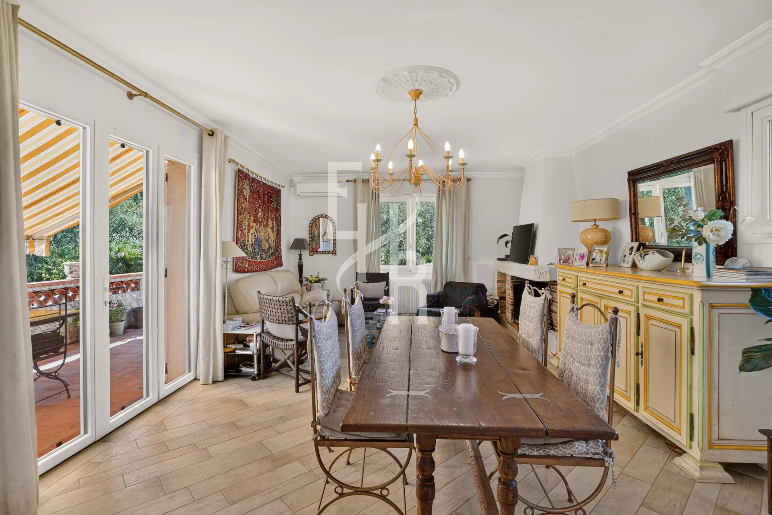 Intérieur d’une villa à Opio Intérieur d'une villa familiale avec salle à manger, cheminée et accès à une terrasse.