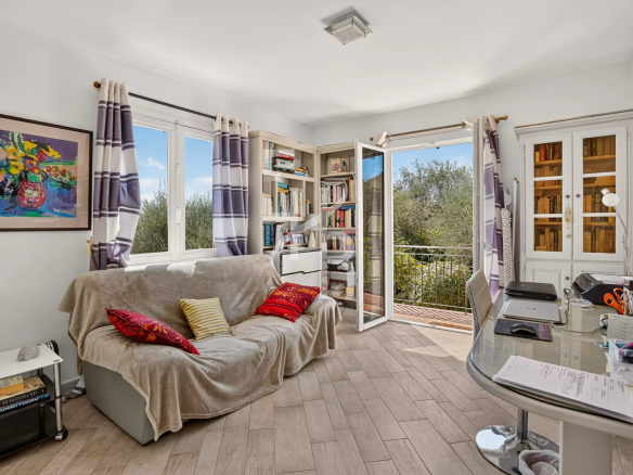 Intérieur d'une villa familiale avec un salon lumineux, un canapé et des étagères, à Opio.