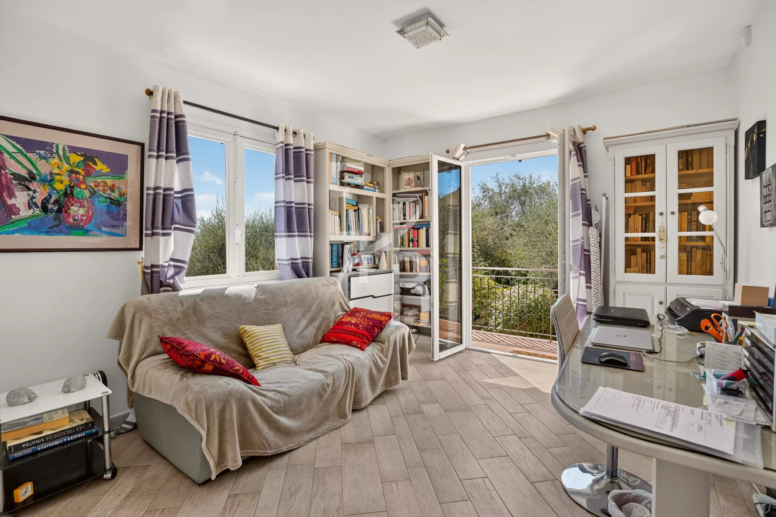 Intérieur d’une villa à Opio Intérieur d'une villa familiale avec un salon lumineux, un canapé et des étagères, à Opio.