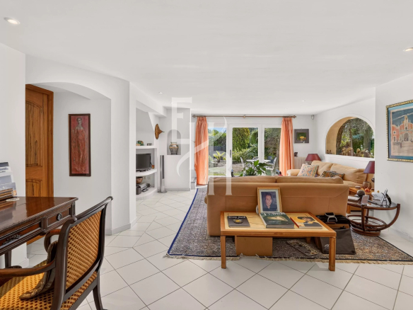 Intérieur d'une villa familiale avec salon lumineux et accès à une terrasse.