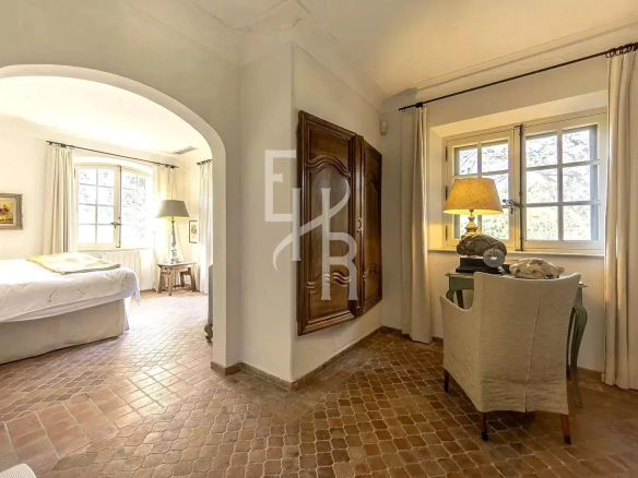 Intérieur d'une maison provençale en pierre à Mougins, montrant une chambre et un coin salon.