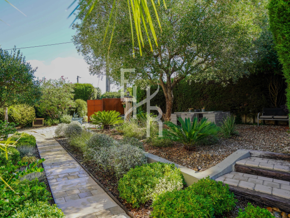 Landscaped garden with walkways and varied vegetation in a villa in Mougins.