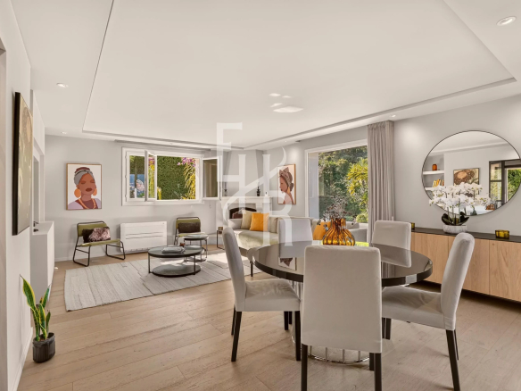 Interior of a modern villa with a bright living room and dining room, decorated with works of art.