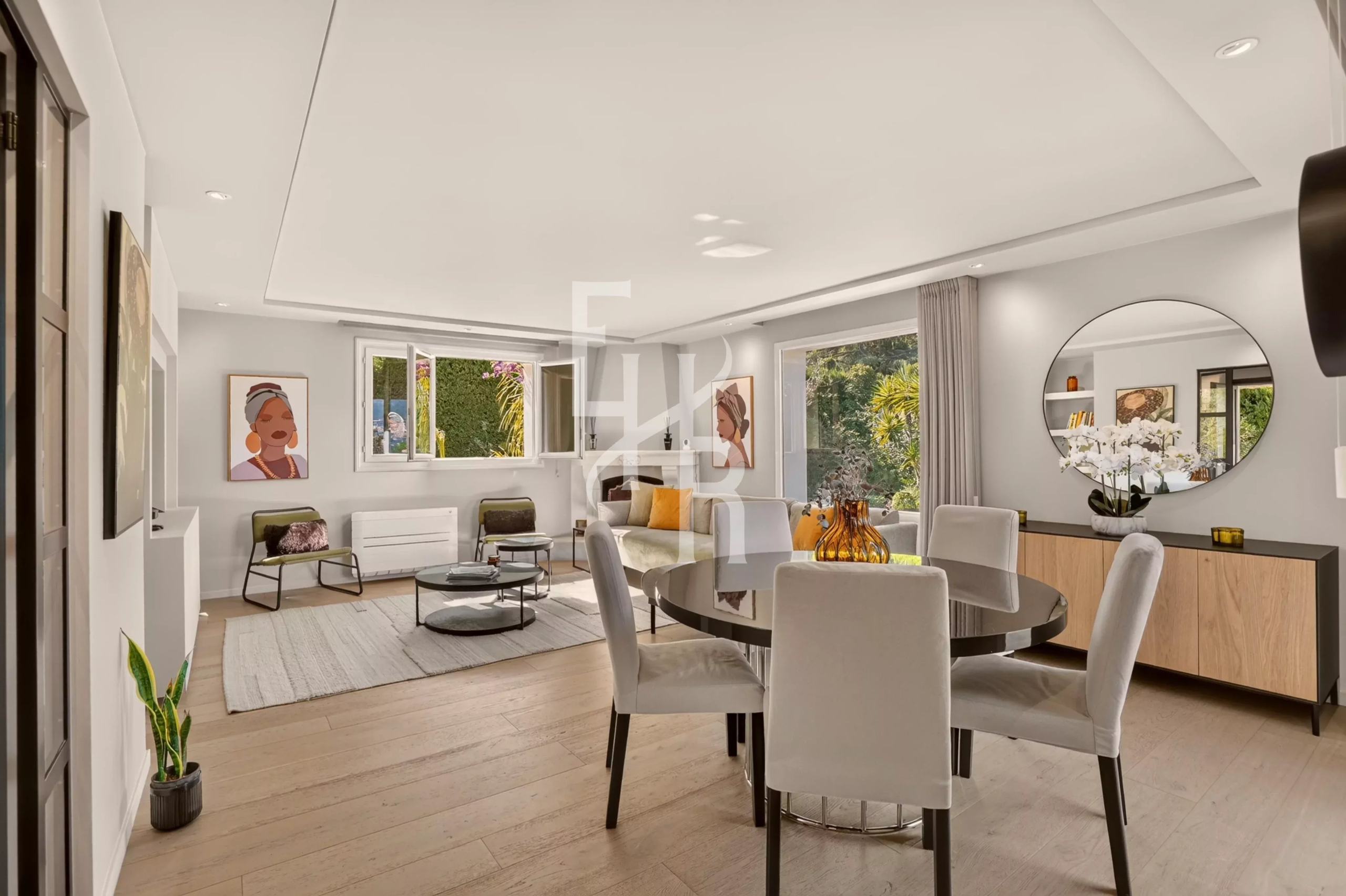 Interior of a villa in Mougins Interior of a modern villa with a bright living room and dining room, decorated with works of art.