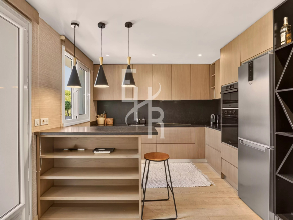 Modern and bright kitchen in a villa in Mougins, with central island and integrated appliances.