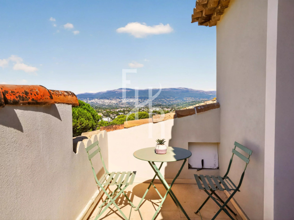 Terrace of a villa in Mougins with views of the hills and garden furniture