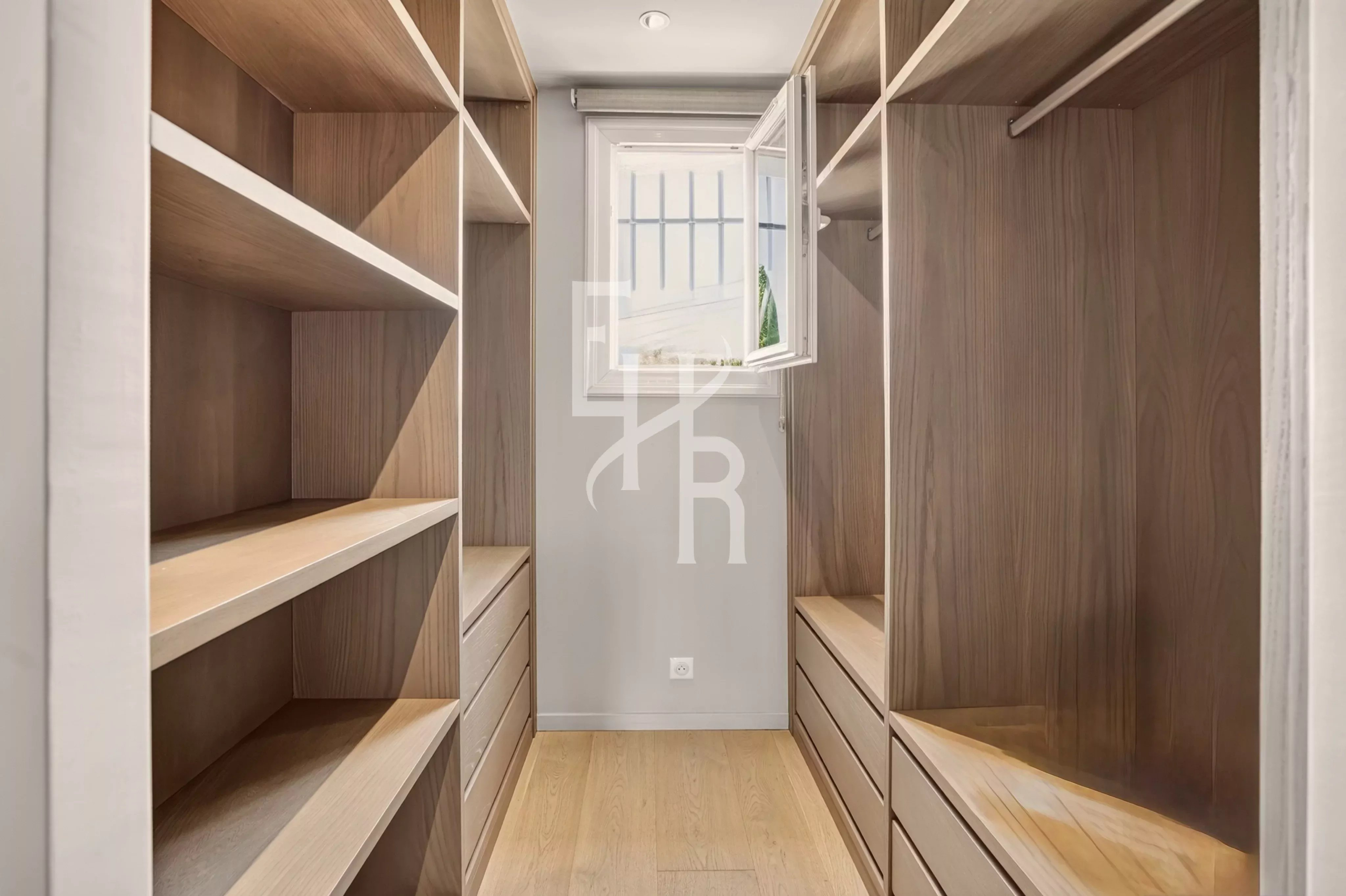 Spacious dressing room Interior of a spacious dressing room with shelves and drawers, natural light entering through a window.