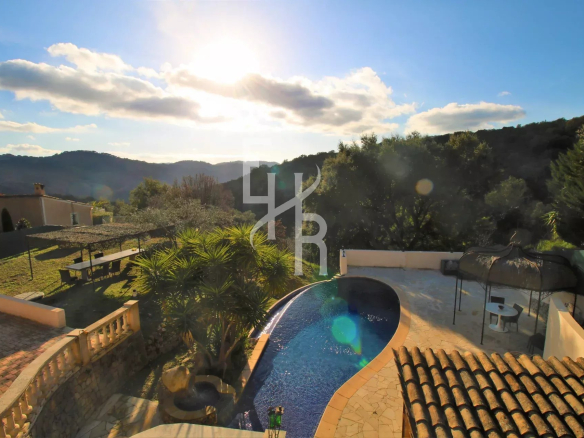 Vue d'une villa avec piscine et paysage montagneux à Peymeinade sous un ciel ensoleillé.