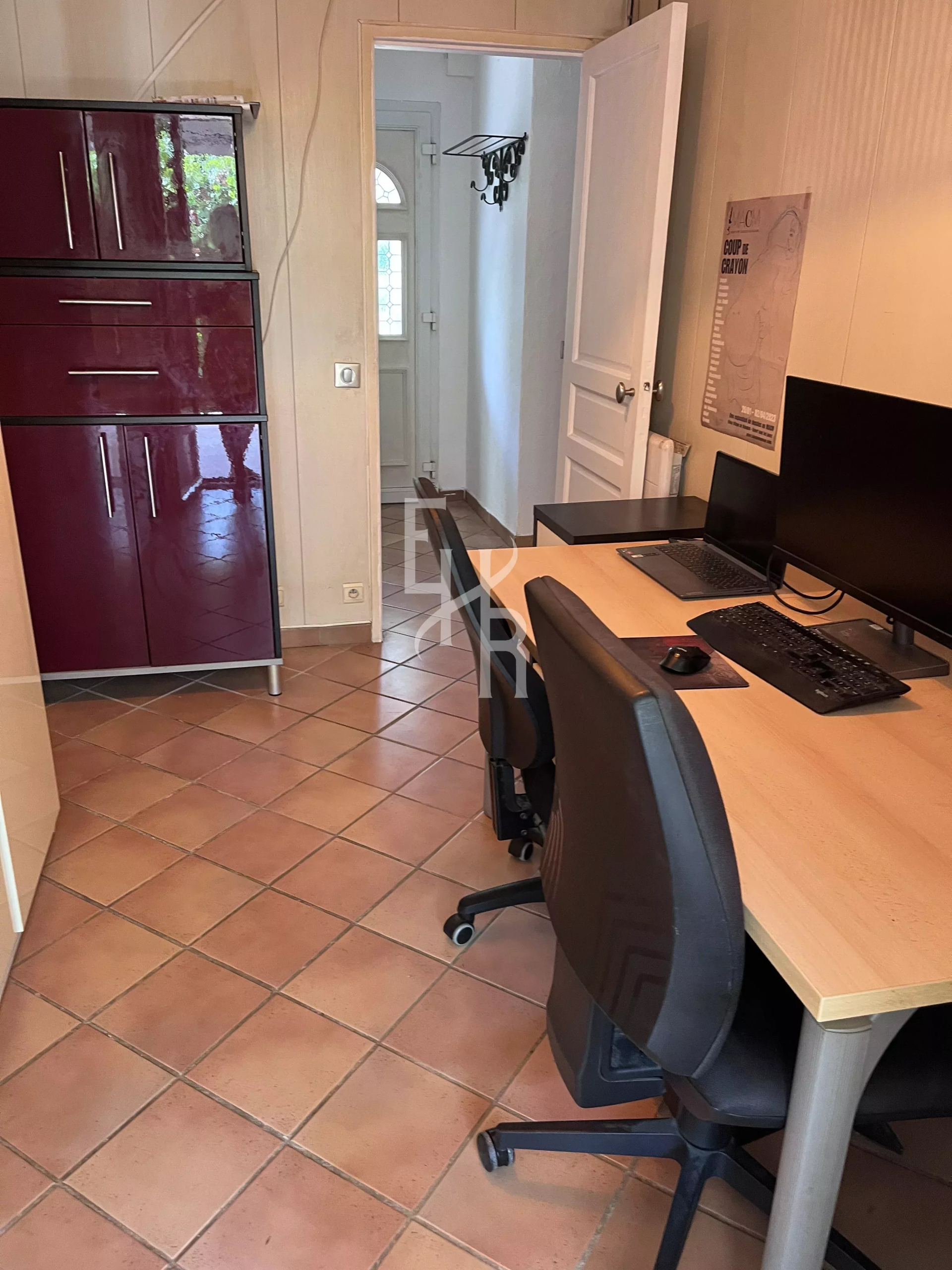 Bureau dans une villa à Mougins Intérieur d'un bureau avec deux chaises et un ordinateur, murs clairs et meubles sombres.