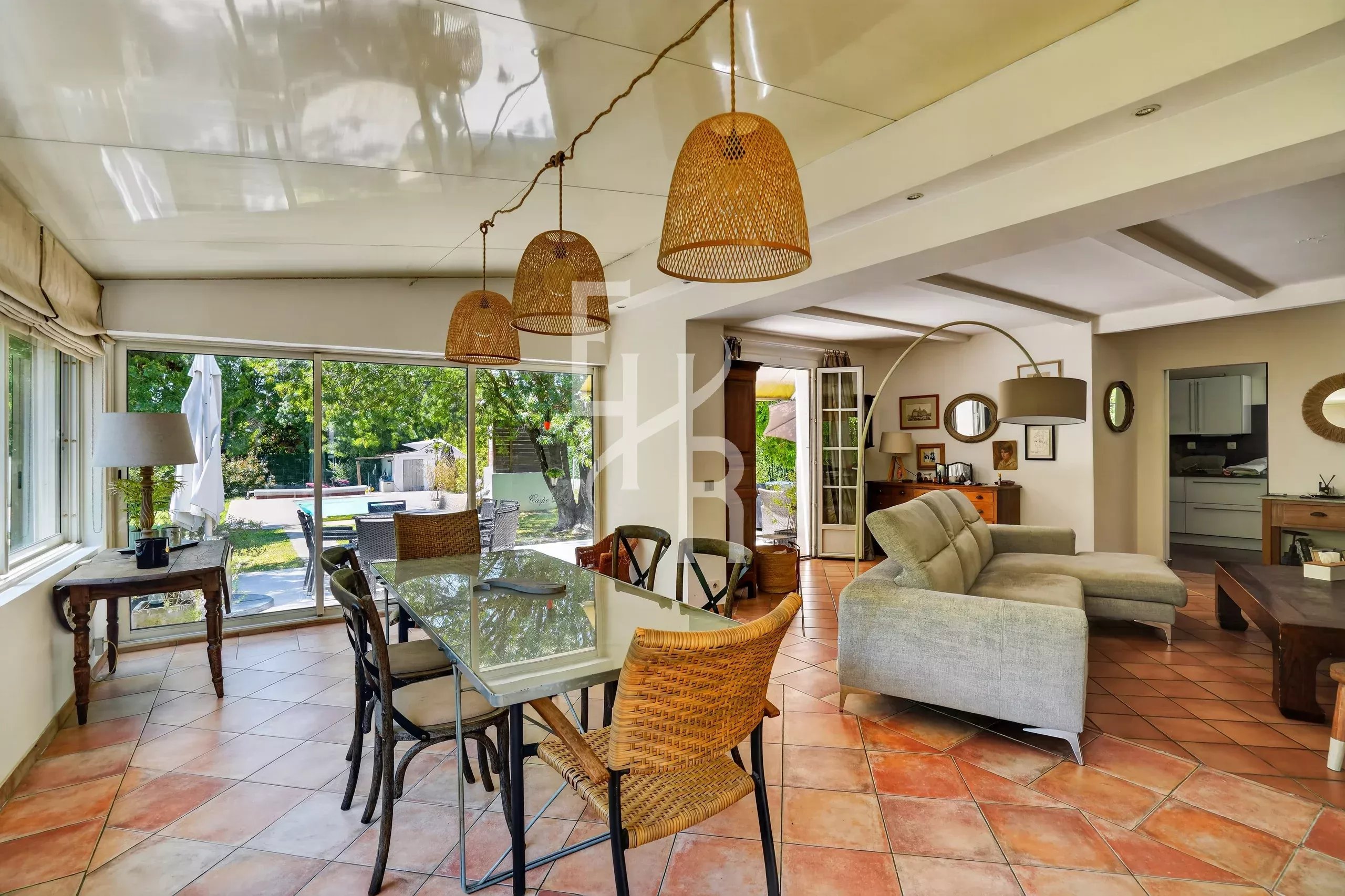 Intérieur d’une villa à Mougins Intérieur d'une villa avec salle à manger et salon lumineux, fenêtres donnant sur le jardin.