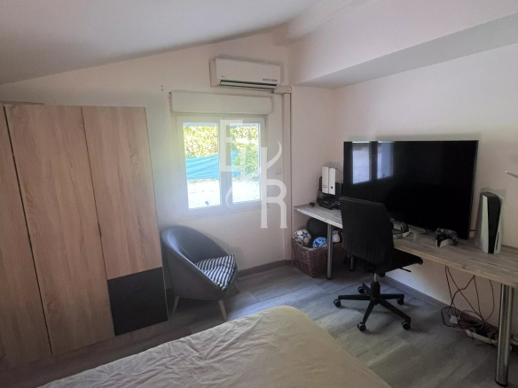 Chambre avec lit, bureau et télévision dans une villa à Mougins.