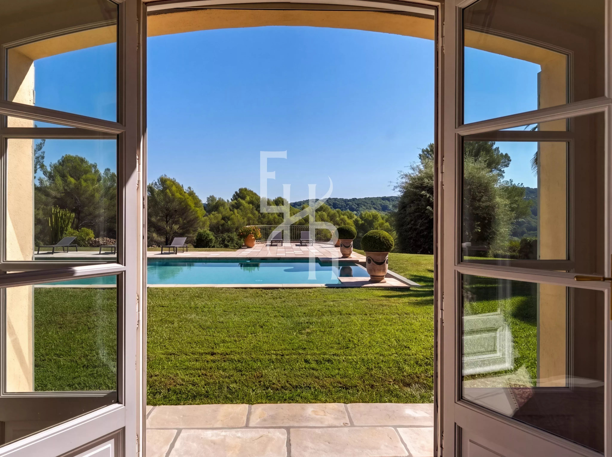 Vue de la villa à Mougins Vue depuis l'intérieur d'une villa sur une piscine et un jardin verdoyant à Mougins.