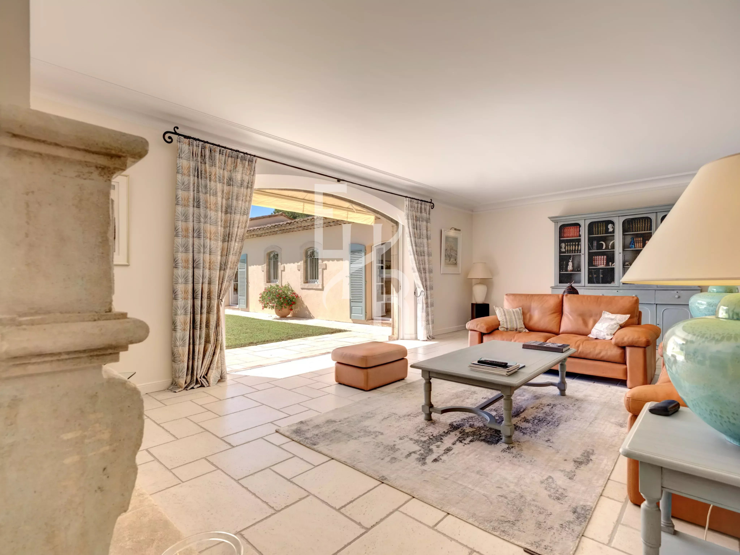 Intérieur d’une villa à Mougins Intérieur d'une villa à Mougins avec un salon spacieux, canapé en cuir et accès à l'extérieur.