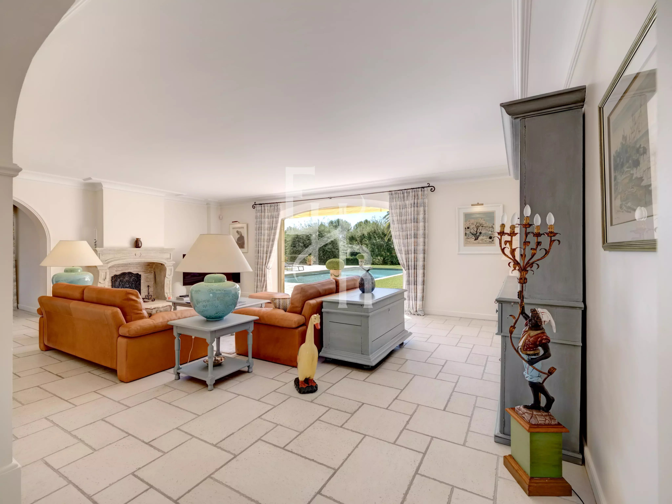 Intérieur d’une villa à Mougins Intérieur d'une villa spacieuse avec salon lumineux, canapés en cuir et vue sur la piscine.