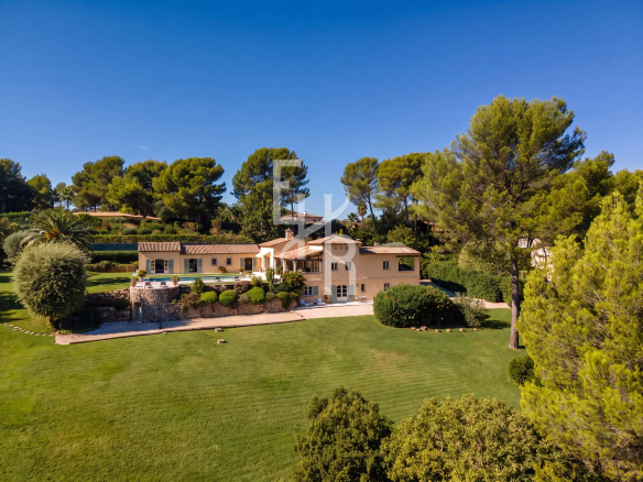 Vue aérienne d'une villa dans un domaine fermé à Mougins, entourée de verdure et avec piscine.