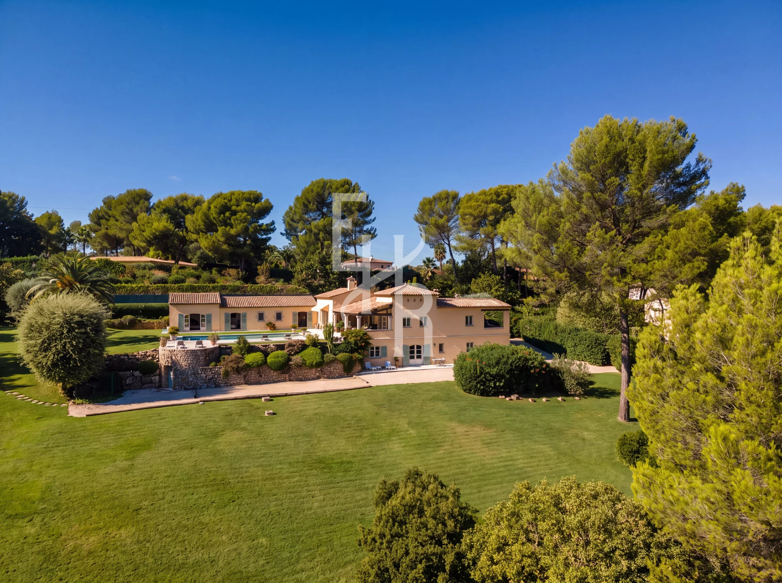 Villa d’exception à Mougins Vue aérienne d'une villa dans un domaine fermé à Mougins, entourée de verdure et avec piscine.