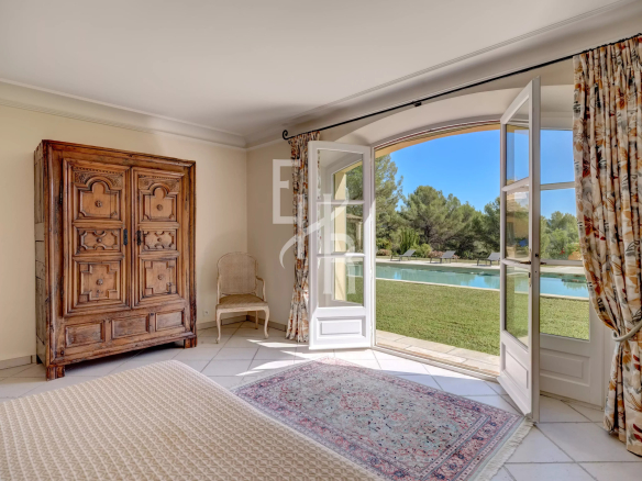 Intérieur d'une villa avec vue sur la piscine et le jardin.