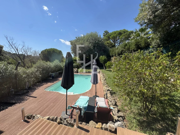 Vue de la piscine chauffée et du jardin d'une villa à Mougins avec terrain plat.