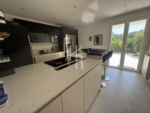 Cuisine moderne et spacieuse d'une villa à Mougins avec accès à l'extérieur.