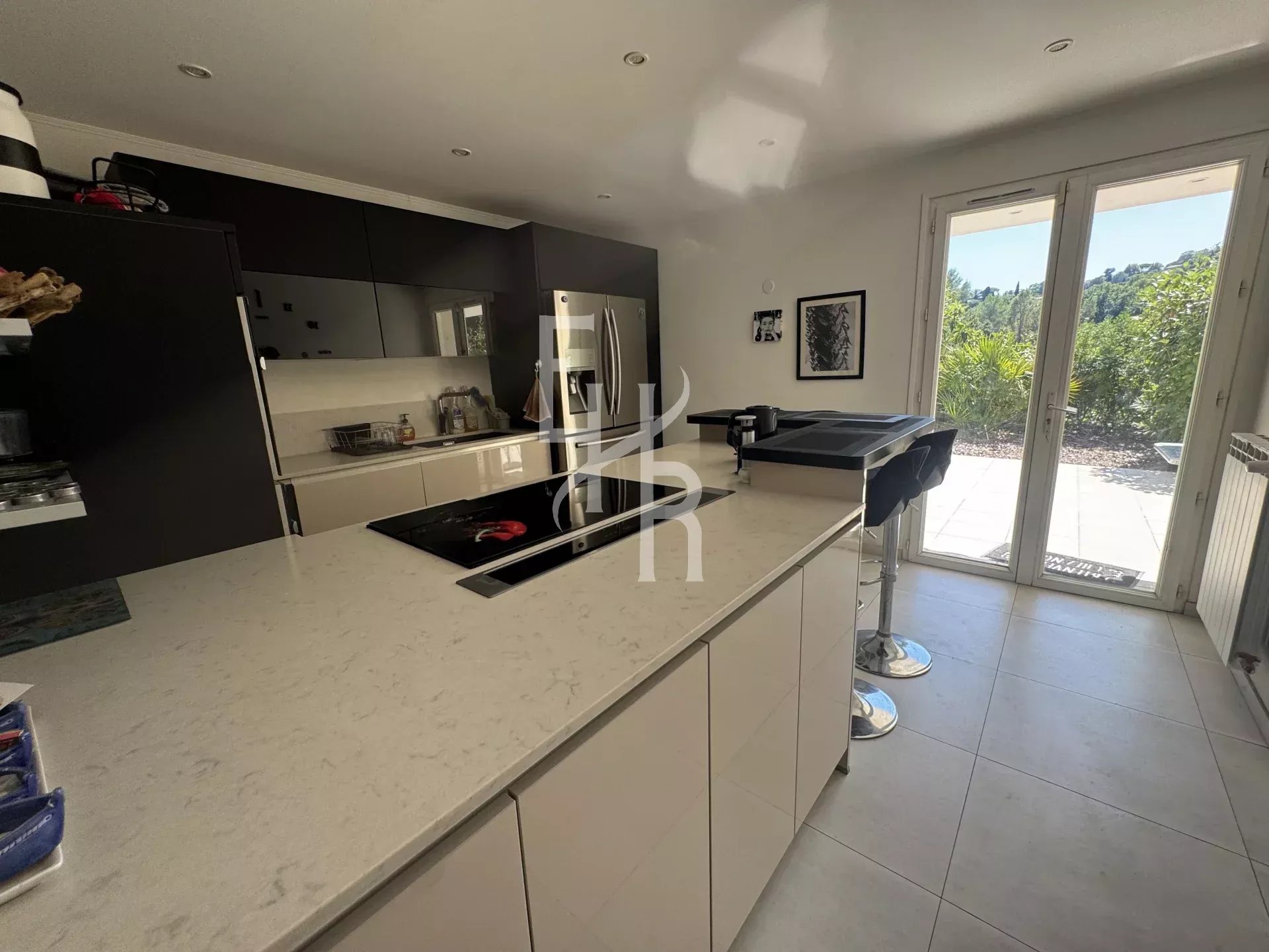 Cuisine de villa à Mougins Cuisine moderne et spacieuse d'une villa à Mougins avec accès à l'extérieur.