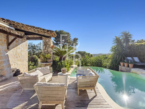 Provençal villa with swimming pool and sea view in Mougins, surrounded by greenery.