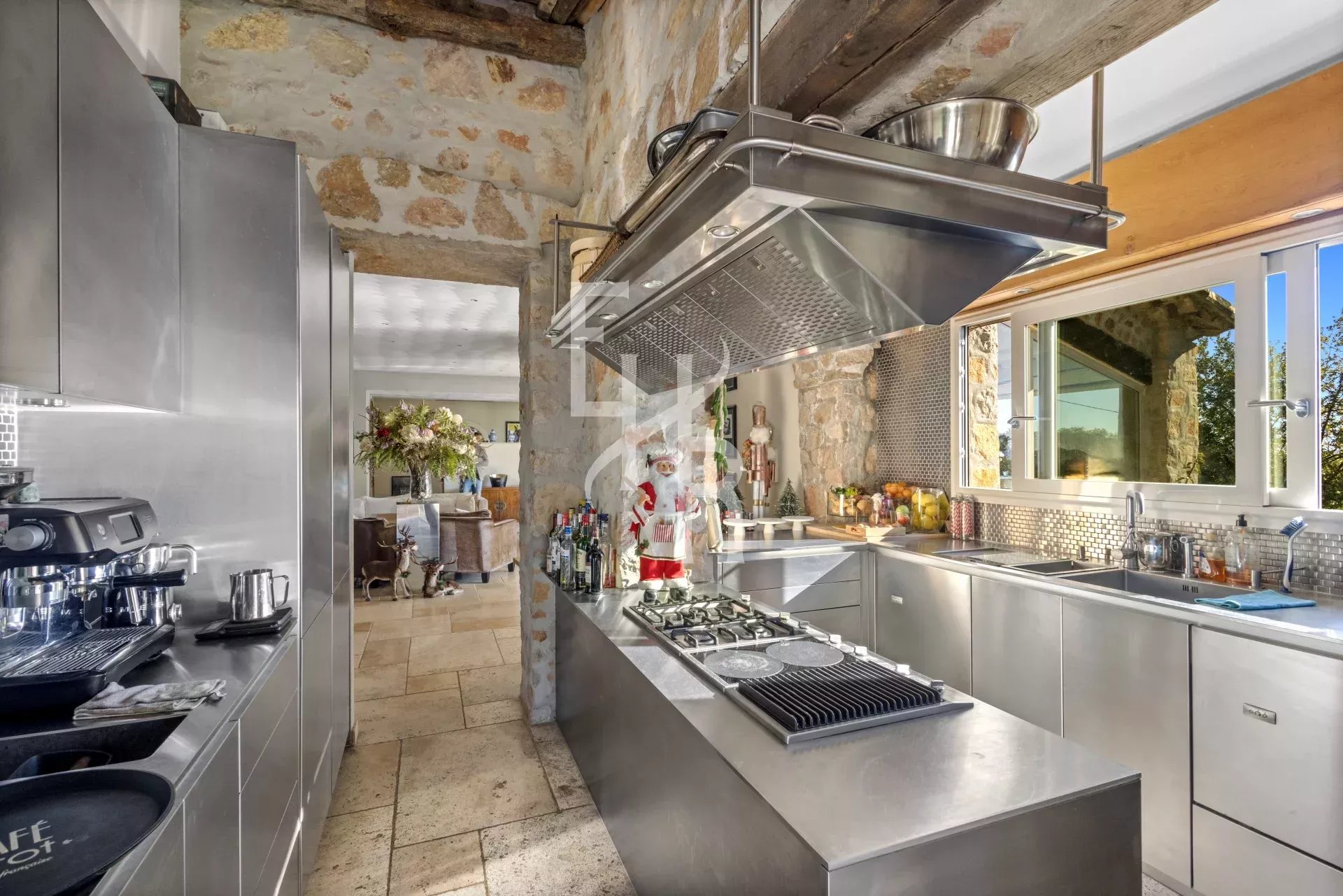 Kitchen of the Provençal Villa in Mougins Modern kitchen in a Provençal villa in Mougins, with stainless steel elements and a view of the living room.