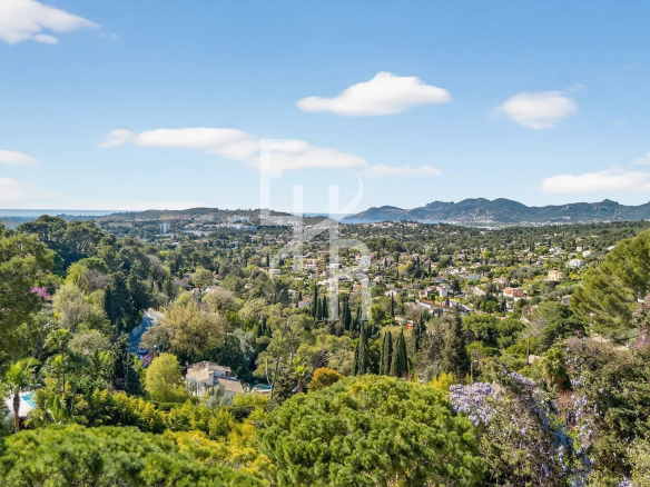 Panoramic view of the Mougins region with the sea in the distance and green hills.