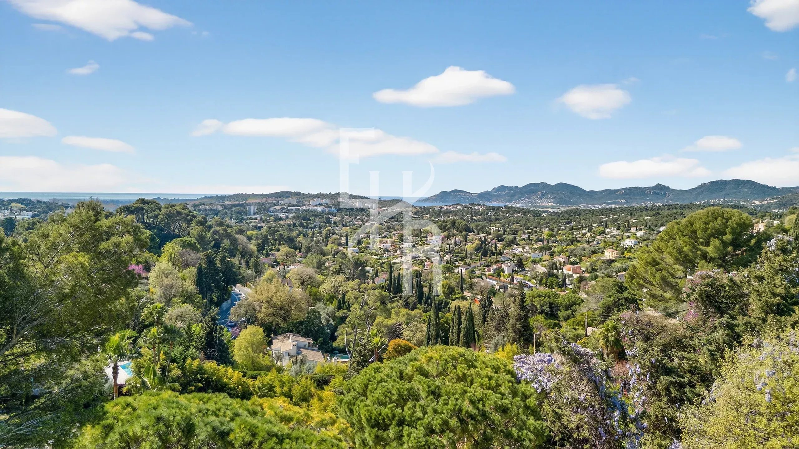 View of Mougins and the sea Panoramic view of the Mougins region with the sea in the distance and green hills.