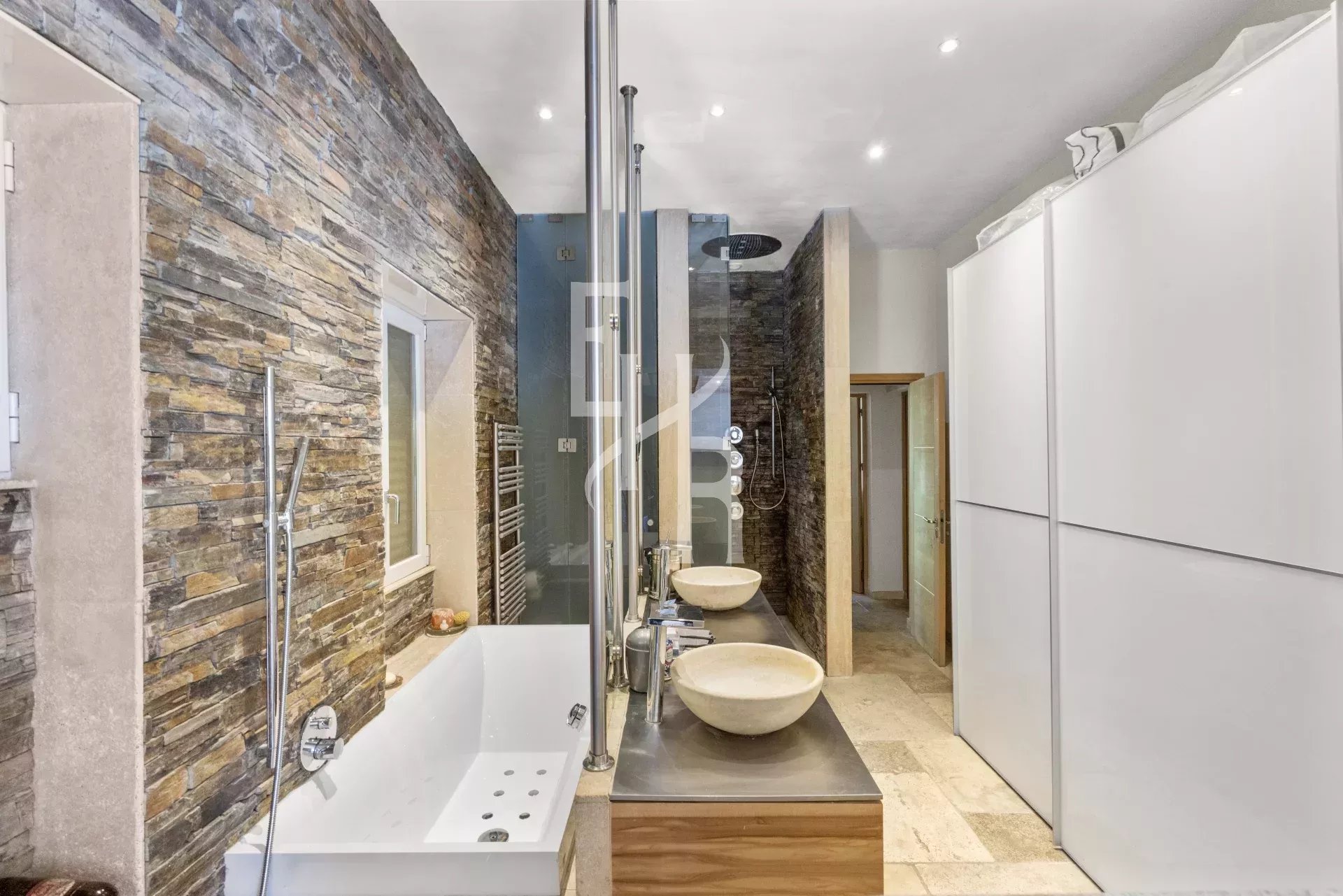 Bathroom of the Provençal villa in Mougins Modern bathroom with bathtub, showers and double stone sink.