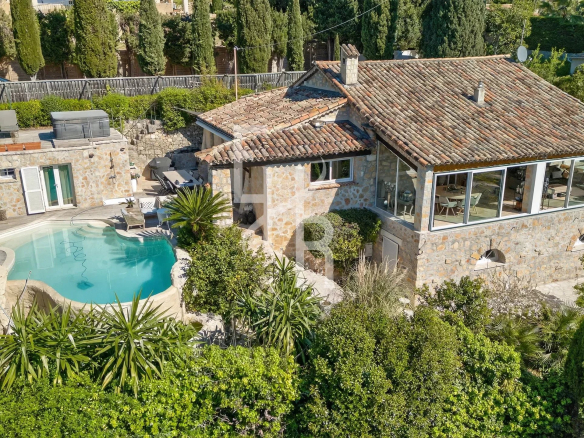 Provençal villa with swimming pool and sea view in Mougins, surrounded by greenery.