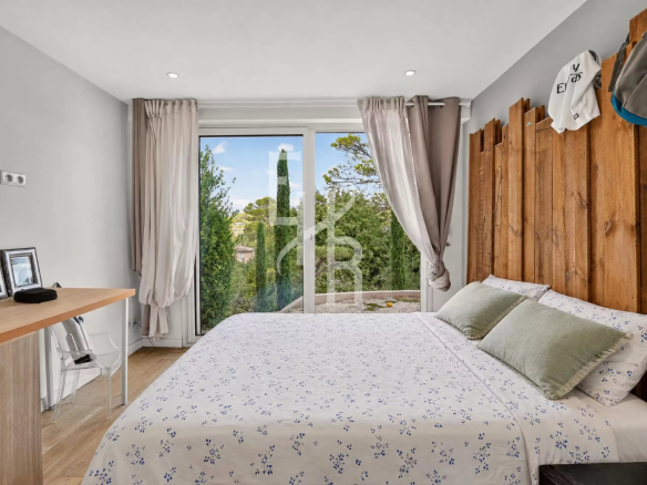 Chambre lumineuse avec lit double et vue sur la nature à Mougins.
