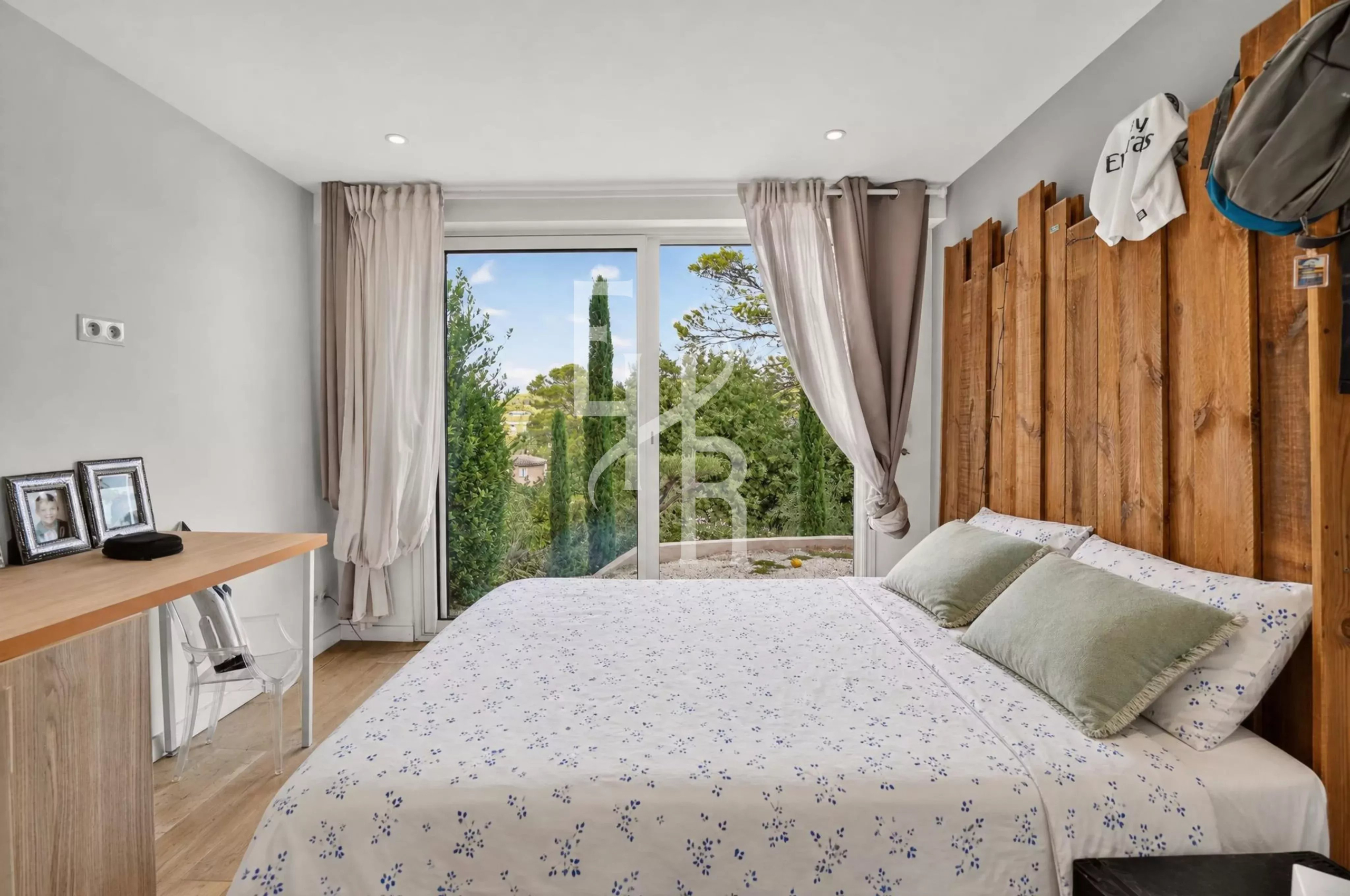 Chambre lumineuse avec lit double et vue sur la nature à Mougins.