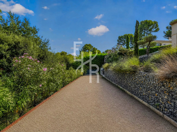 Chemin d'accès bordé de végétation dans le Domaine de la Peyrière à Mougins.