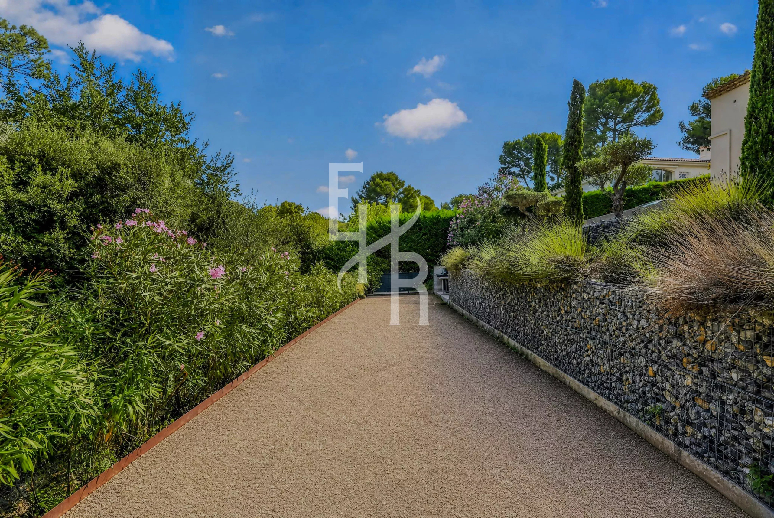 Chemin d'accès bordé de végétation dans le Domaine de la Peyrière à Mougins.