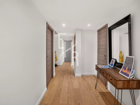 Couloir lumineux d'une villa moderne avec parquet en bois et portes en bois, à Mougins.