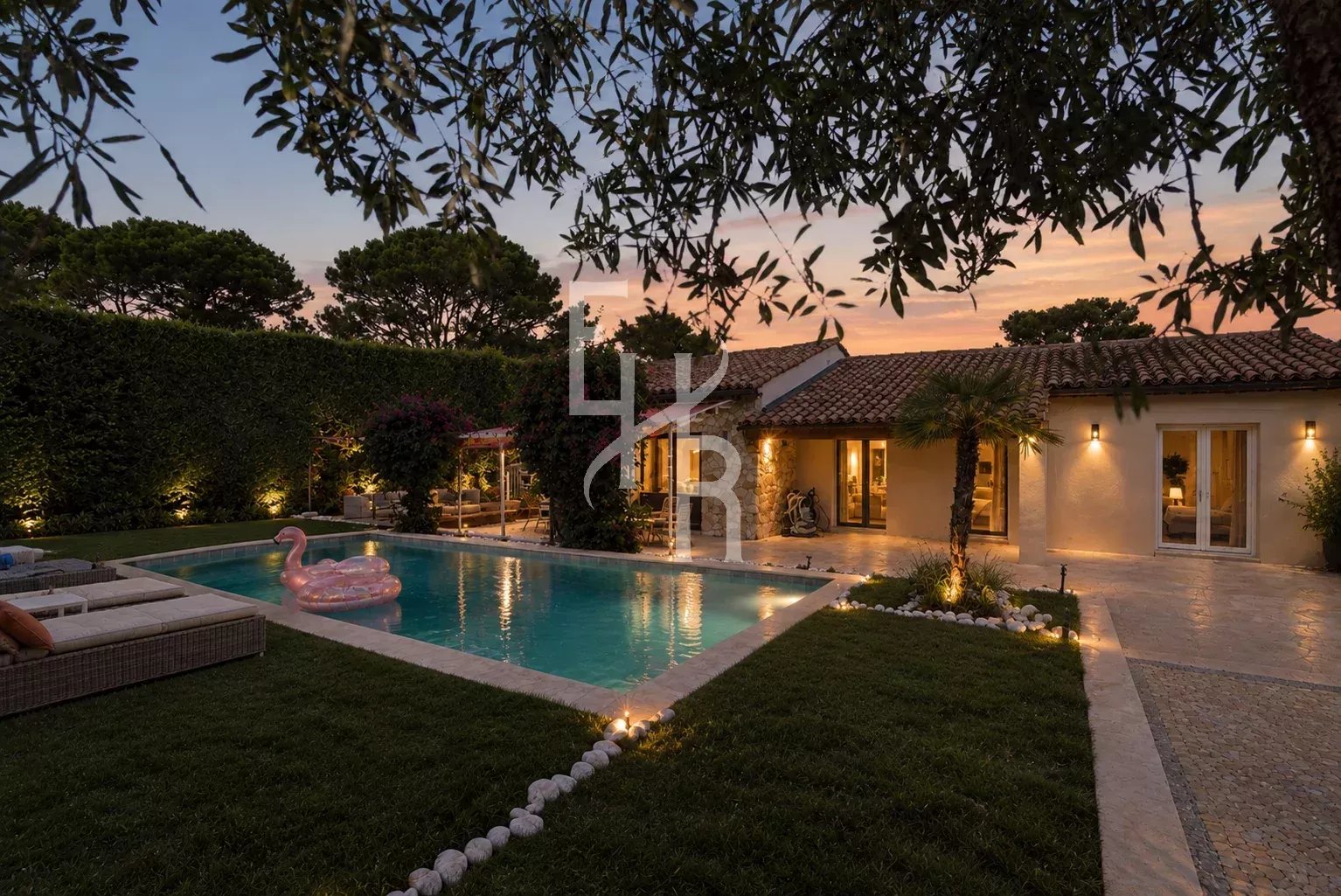 Villa avec piscine et jardin à Mougins, éclairée au crépuscule.