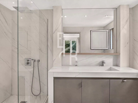 Salle de bain moderne avec douche en verre et meuble sous vasque en marbre