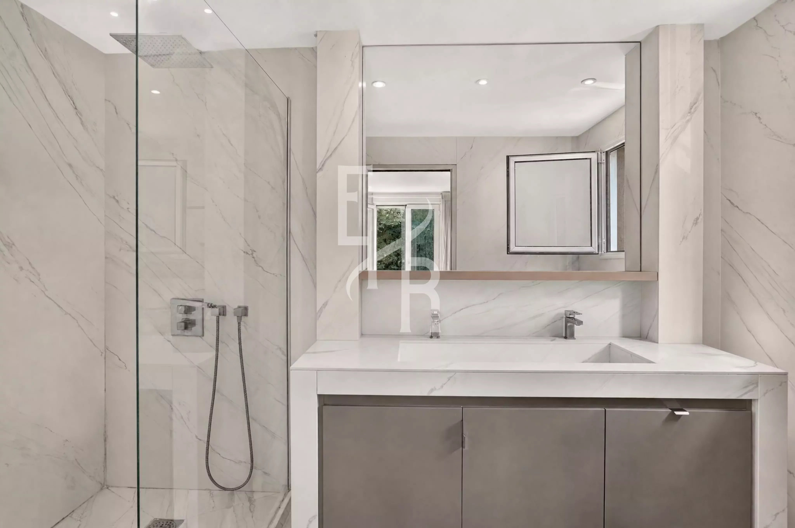 Salle de bain moderne avec douche en verre et meuble sous vasque en marbre