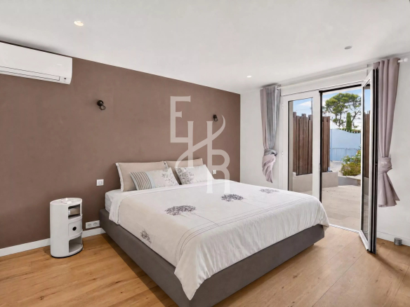 Chambre d'une villa moderne avec lit double et accès à une terrasse extérieure à Mougins.