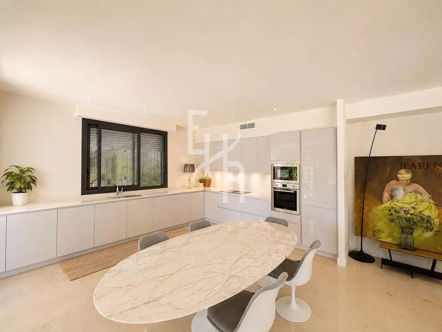 Modern kitchen with oval table and chairs in an apartment in Cannes